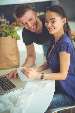 Çift evde mutfak içinde laptop ile onların fatura ödeme