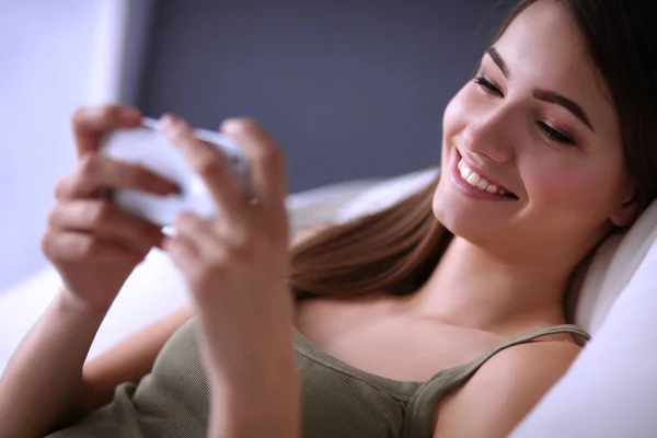 Mooie vrouw in haar woonkamer liggend op de bank verzenden puinhoop — Stockfoto