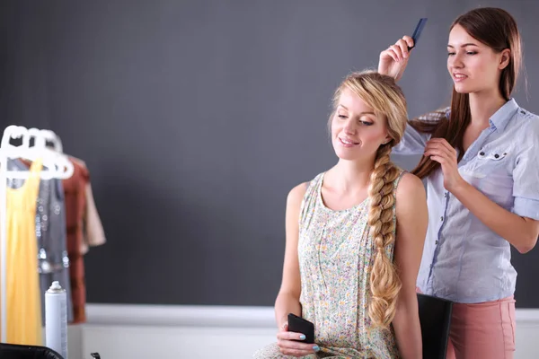 Young woman hairdresser do hairstyle girl in salon