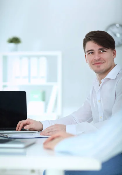 Молодой бизнесмен работает в офисе, сидит за столом — стоковое фото