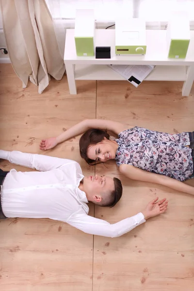 Lykkelig ungt par som ligger sammen på gulvet – stockfoto