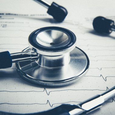 Masada yatan elektrokardiyogramda stetoskop.