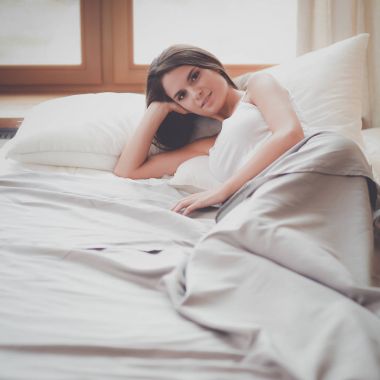 Evdeki yatakta uzanmış güzel esmer