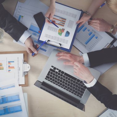 İş adamları iş toplantısında, ofiste oturup tartışıyorlar.