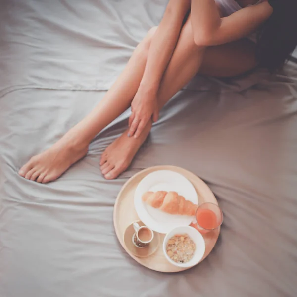 Wanita muda duduk di tempat tidur dengan secangkir susu — Stok Foto