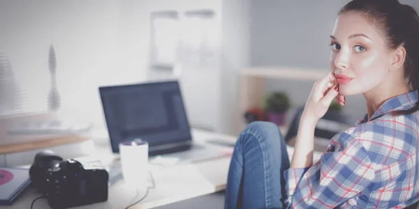 Vrouwelijke fotograaf zittend op het bureau met laptop — Stockfoto