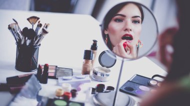 Genç güzel kadın ayna, Masa başında oturan yakınındaki makyaj yapma