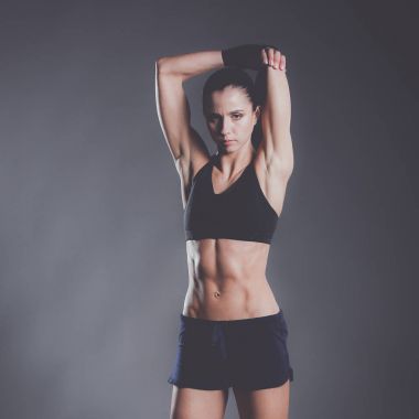 Spor giyim siyah arka plan karşı poz kas genç kadın