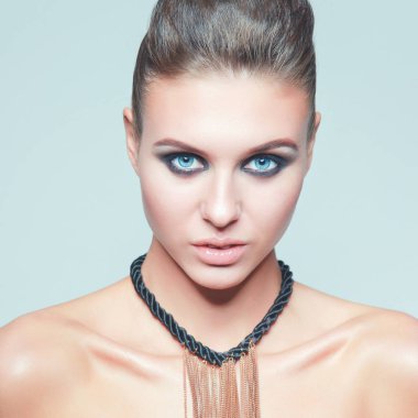 Gri arka plan üzerinde duran güzel genç kadın