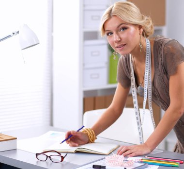 Stüdyoda çalışan genç moda tasarımcısı.