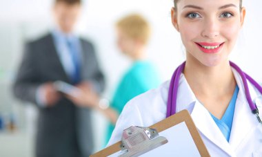 Kadın doktor hastanede dosyayla bekliyor.