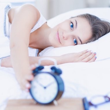 Genç bir kadın sabah alarmını erteliyor.