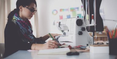 Çalışırken dikiş diken genç bir kadın.