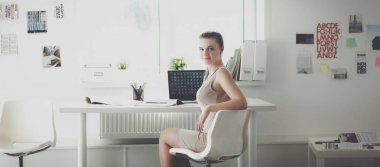 Masasında ve bilgisayarında evrakları olan bir kadın.