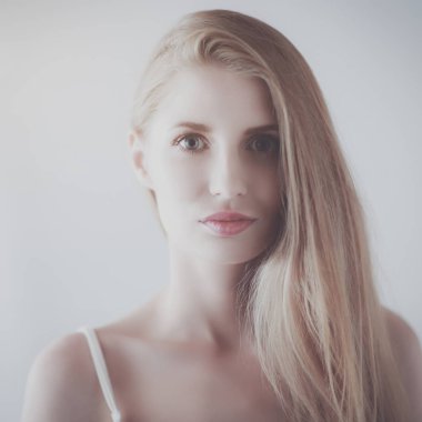 Gri arka planda izole edilmiş güzel bir kadının portresi.