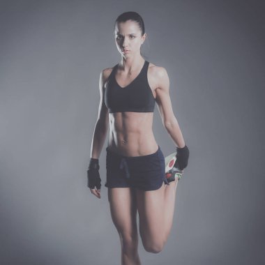 Spor giyim siyah arka plan karşı poz kas genç kadın