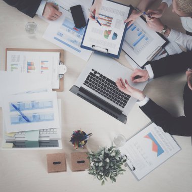 İş adamları iş toplantısında, ofiste oturup tartışıyorlar.