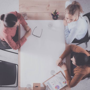 İş adamları toplantıda, ofiste oturup tartışıyorlar.