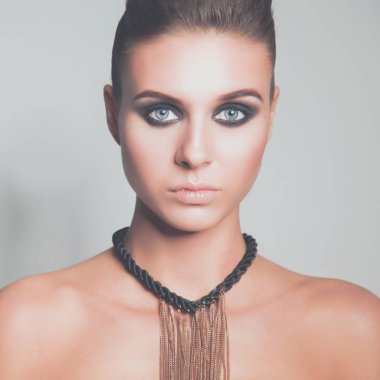 Gri arka plan üzerinde duran güzel genç kadın