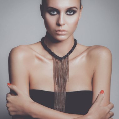 Gri arka plan üzerinde duran güzel genç kadın