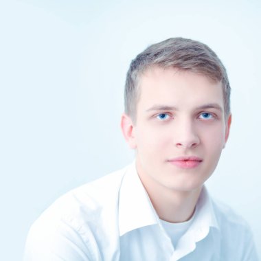 Gri arka plan üzerinde oturan gülümseyen genç adam portresi