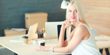 Moda tasarımcıları stüdyoda çalışıyor. Masanın üzerinde oturuyorlar.