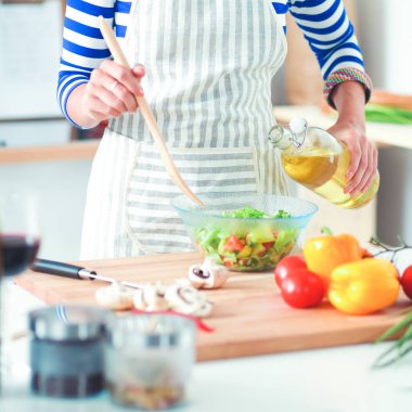 Genç kadın taze salata hazırlıyor.