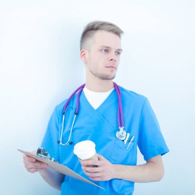 Steteskoplu doktor ayakta, çapraz kollu, beyaz arka planda izole.