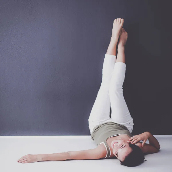 Young woman lying on the floor with legs up — Stock Photo, Image