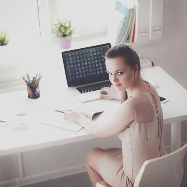 Жінка з документами, що сидять на столі і ноутбуці — стокове фото
