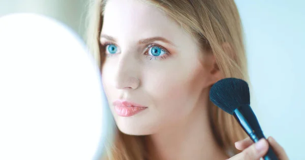 Pretty woman applying make up with brush — Stock Photo, Image