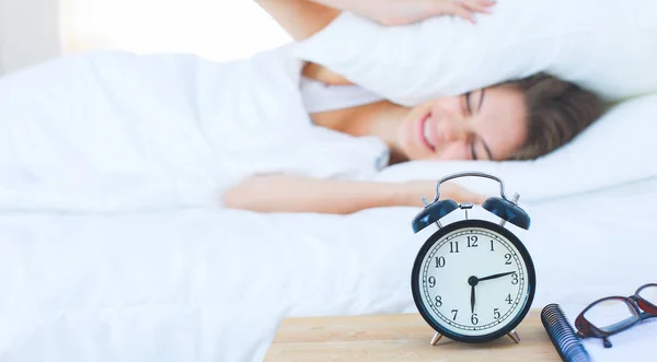 A young woman putting her alarm clock off in the morning — Stock Photo, Image