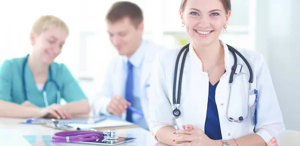 Bella giovane sorridente medico femminile seduto alla scrivania — Foto Stock