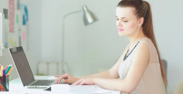 Mujer con documentos sentados en el escritorio y el ordenador portátil — Foto de Stock