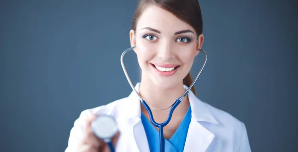 Ärztin mit Stethoskop hört zu, isoliert auf grauem Hintergrund — Stockfoto
