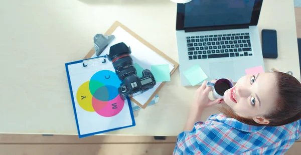 Vrouwelijke fotograaf zittend op het bureau met laptop — Stockfoto