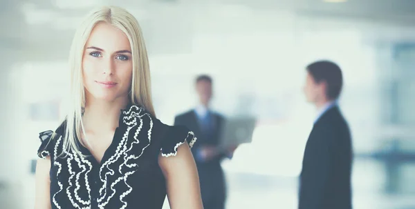 Affärskvinna som står i förgrunden i office — Stockfoto
