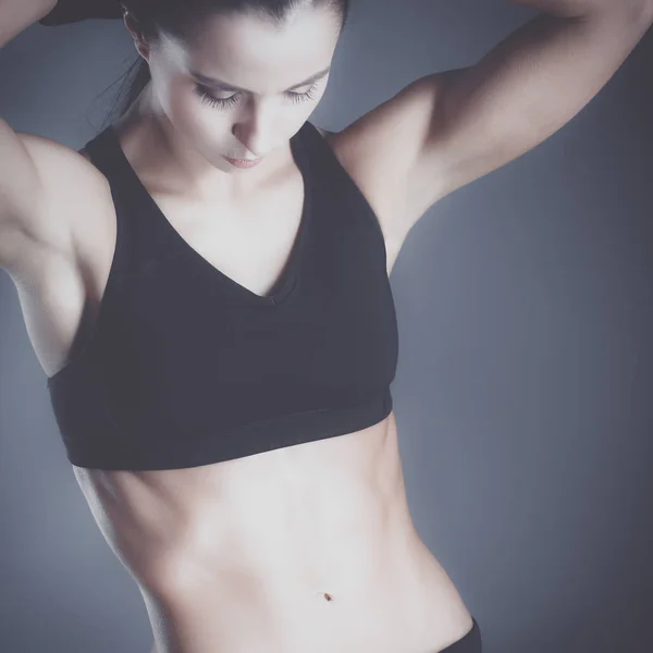 Musculosa joven posando en ropa deportiva sobre fondo negro —  Fotos de Stock