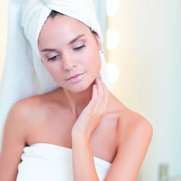 Young attractive woman standing in front of bathroom mirror — Stock Photo, Image