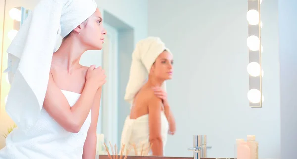 Mladá atraktivní žena stojící před zrcadlo do koupelny — Stock fotografie