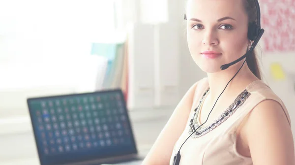 Mooie zakenvrouw werken aan haar bureau met headset en laptop — Stockfoto