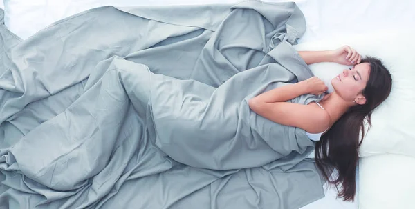 Красивая брюнетка лежит на кровати дома — стоковое фото