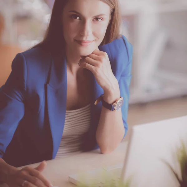 Woman sitting on the desk with laptop — Stock Photo, Image