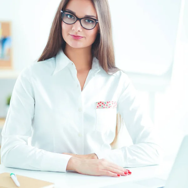 Empresária atraente sentada na mesa no escritório — Fotografia de Stock