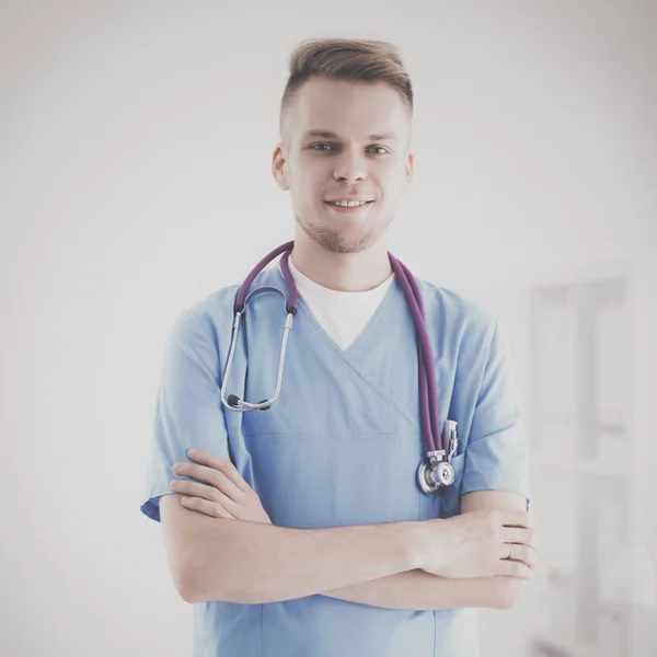 Médico con estetoscopio de pie, brazos cruzados, aislado sobre fondo blanco — Foto de Stock