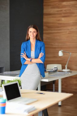 İş yerinin yanında duran güzel bir iş kadınının portresi.