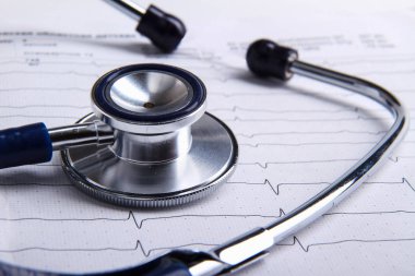 Masada yatan elektrokardiyogramda stetoskop.