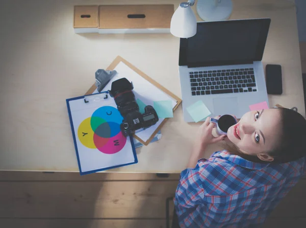 Femme photographe assise sur le bureau avec ordinateur portable — Photo