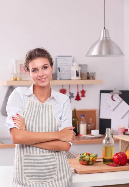 Usmívající se mladá žena stojící v kuchyni — Stock fotografie
