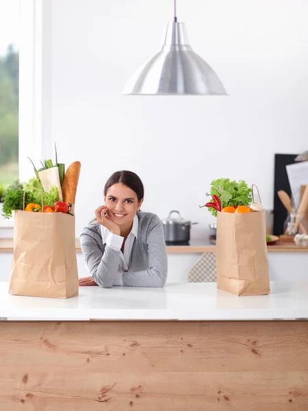 Lachende jonge vrouw in de keuken in de buurt van Bureau — Stockfoto